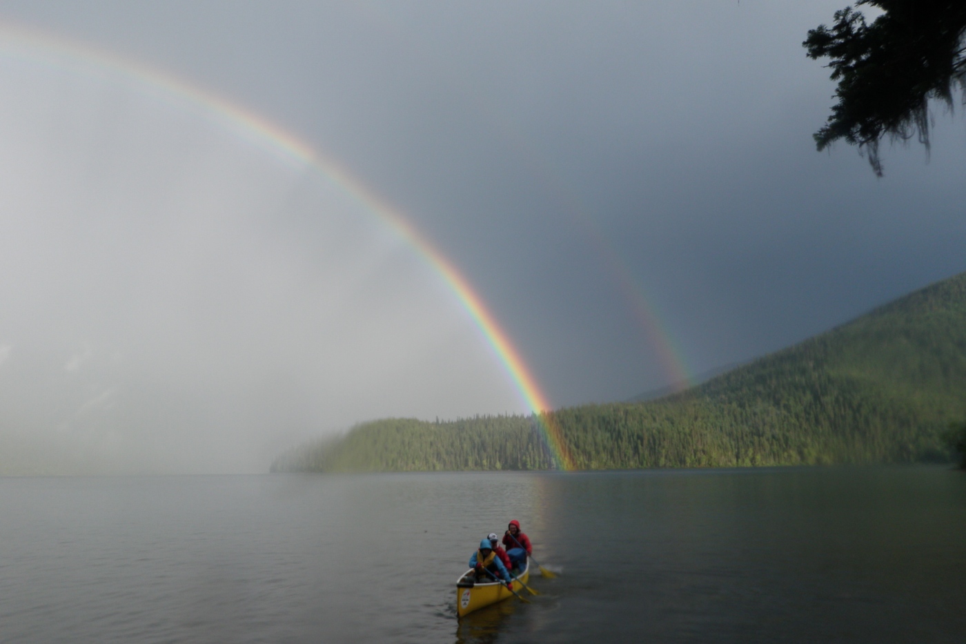 Canoeing wilderness adventure with rainbow